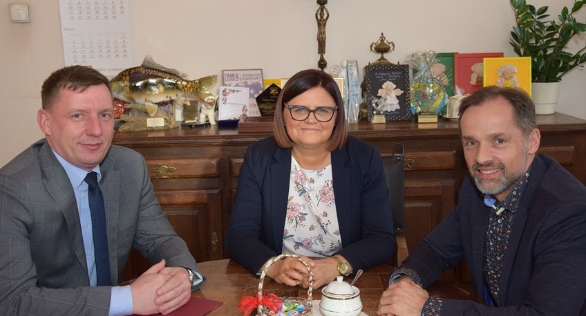 Zdjęcie przedstawia trzy osoby siedzące przy stole: z lewej strony Wicewojewoda Wielkopolski Pan Maciej Bieniek, na środku Starosta Szamotulski Pani Beata Hanyżak, a po prawej stronie Wicestarosta Szamotulski Pan Rafał Zimny.