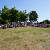 Uczestnicy wydarzenia piknikują na polanie 