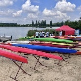 Kolorowe Kajaki wyciągnięte na brzeg, odwrócone i ustawione na stojakach na plaży jeziora Pamiątkowskiego