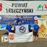 Zawodnicy klubu LUKS „Gry Logiczne” z Wronek z banerem klubowy, i powiatowym