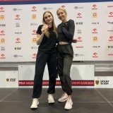 Zawodniczki Wiktoria Knutowicz i Hanna Biniakiewicz na tle podium 